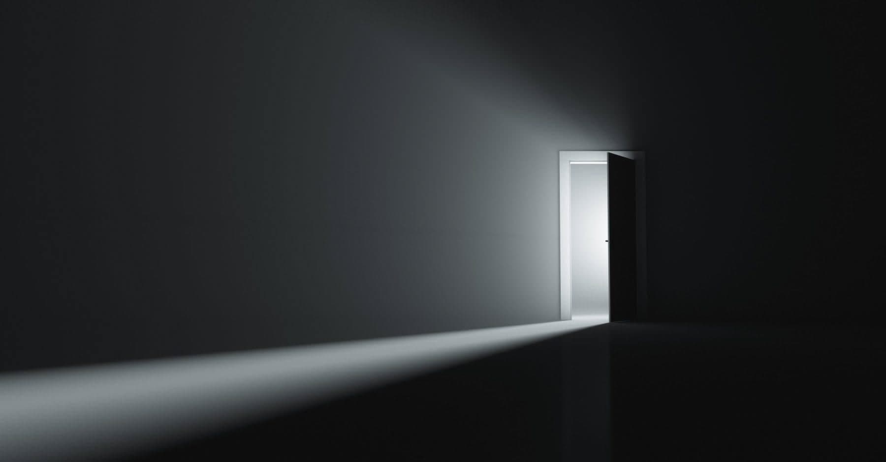 Open door casting light into a dark room