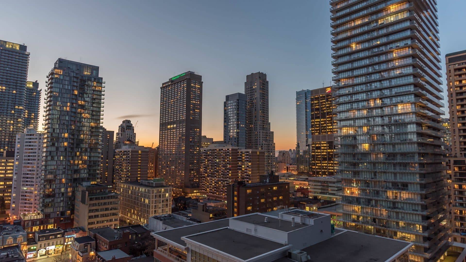 Residential towers at dusk with windows beginning to light up