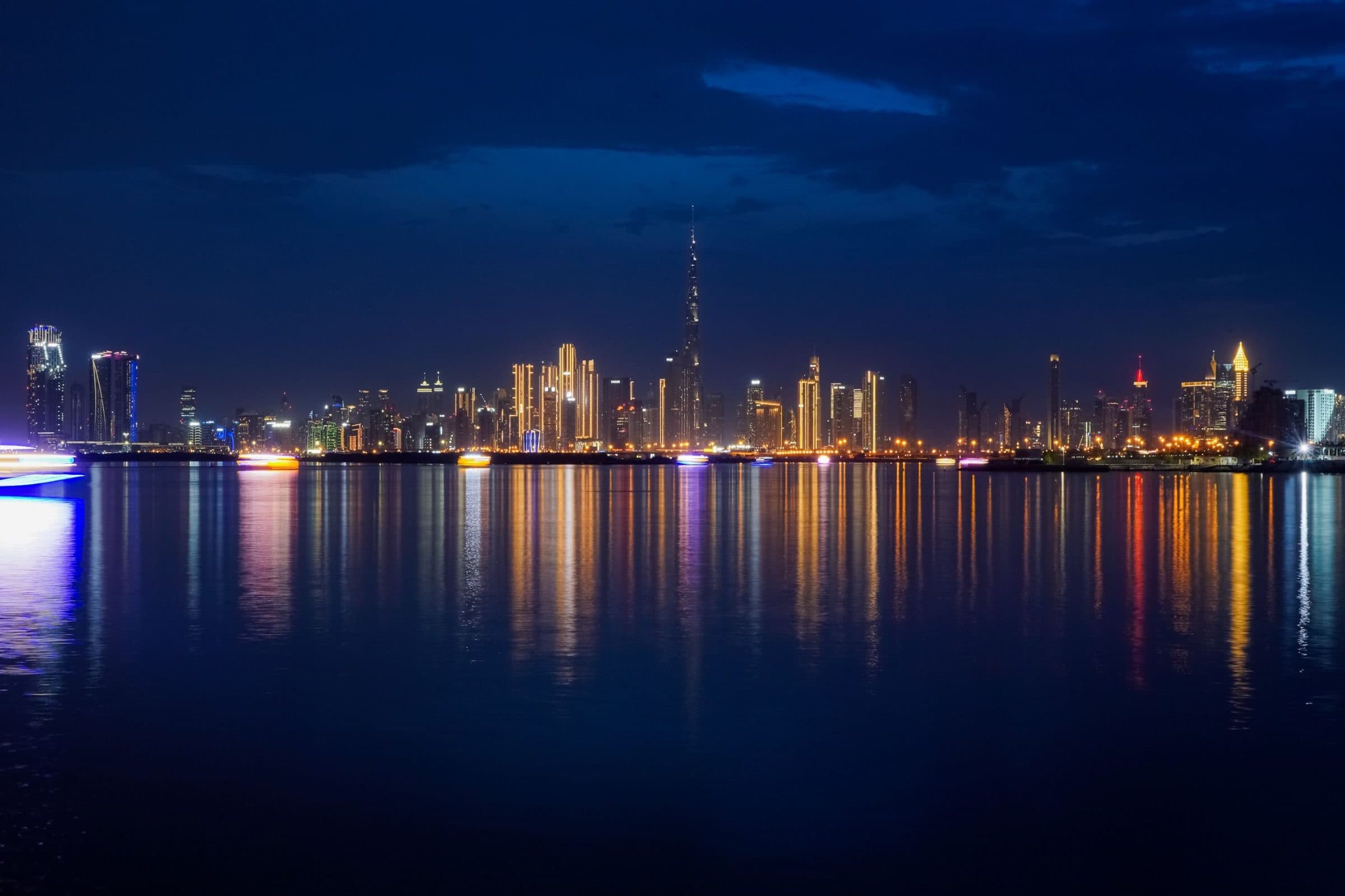 Dubai Marina towers at night reflected in the still water of the marina