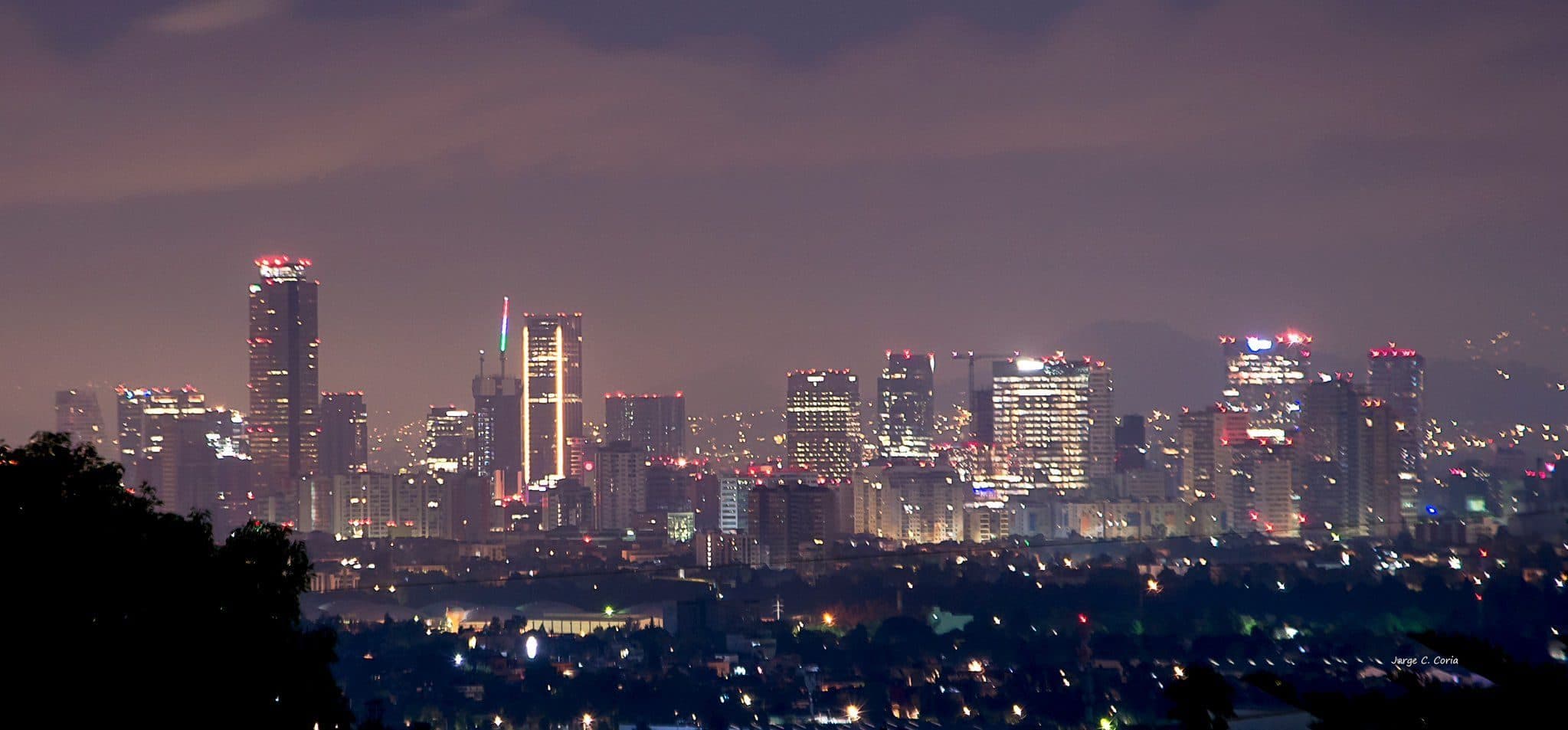 Mexico City skyline at dusk under a hazy purple sky