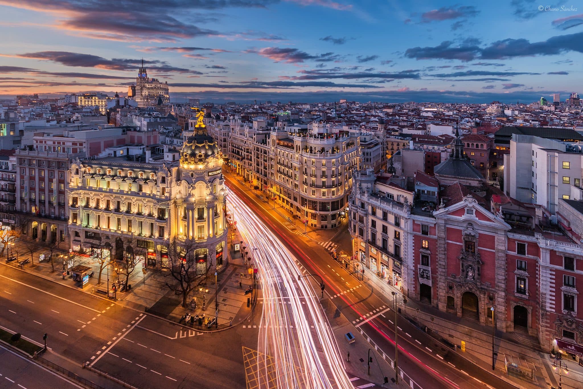 Gran Vía in Madrid at dusk with traffic trails and the Metropolis building lit