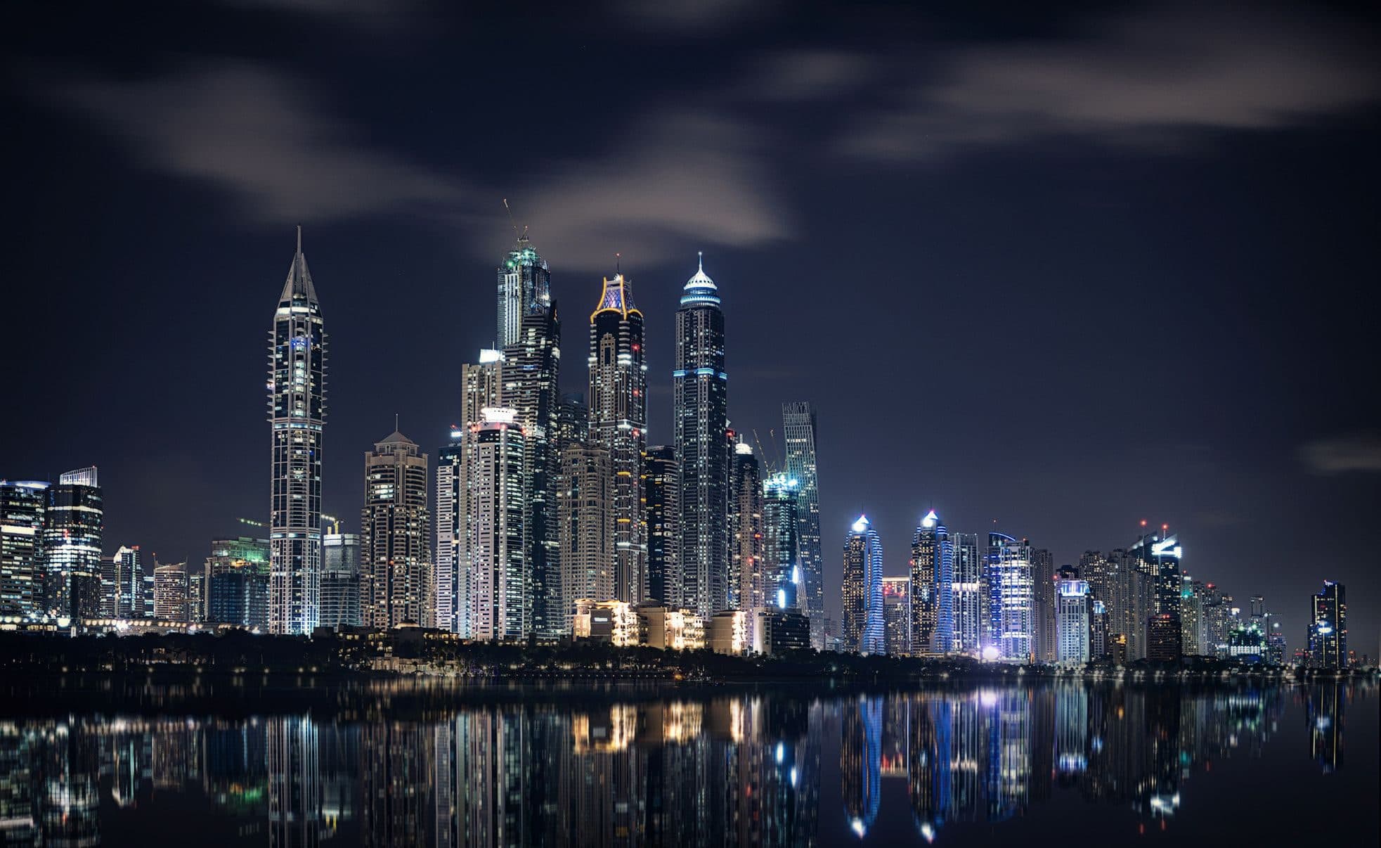 Dubai Marina towers reflected in the water at night