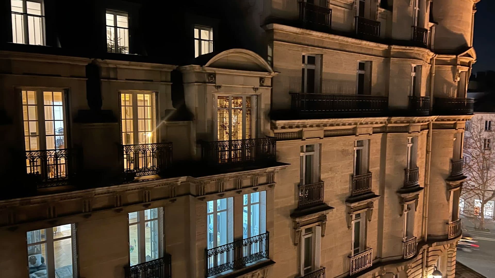 Parisian apartment facades with lit windows at night