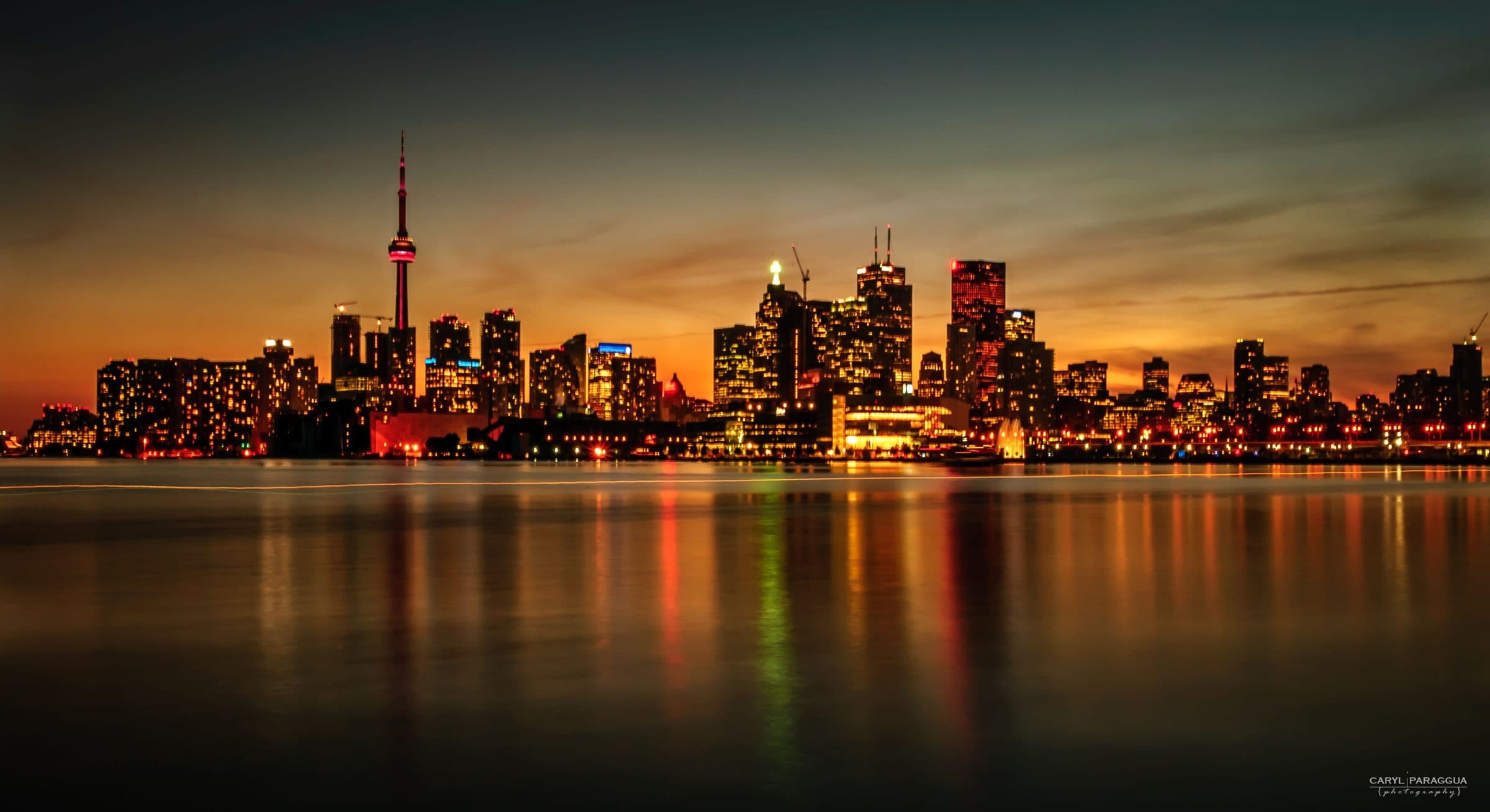 Wide panorama of a city skyline at night with every tower lit
