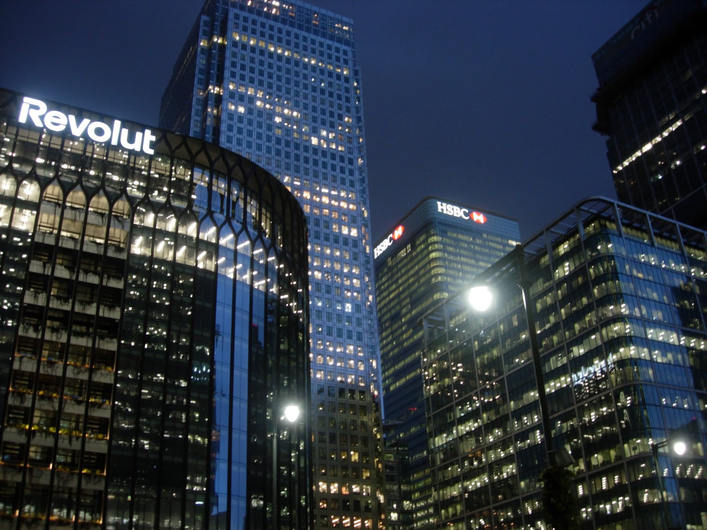 Glass office towers at night with a few floors still lit