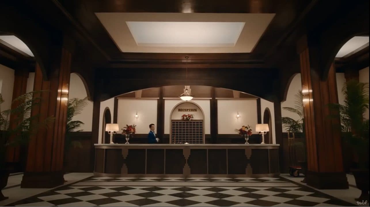 Hotel reception desk with a single concierge, lit from above