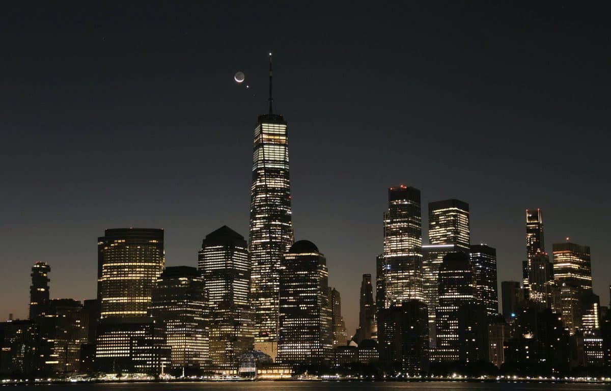 Lower Manhattan skyline at dusk with the towers half lit