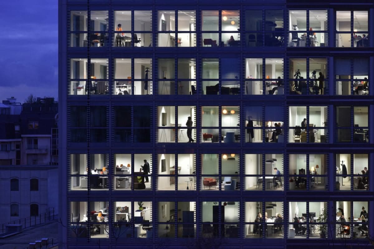 Office building facade at dusk, every window lit