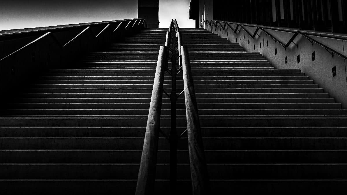 Long stone staircase climbing toward a lit doorway