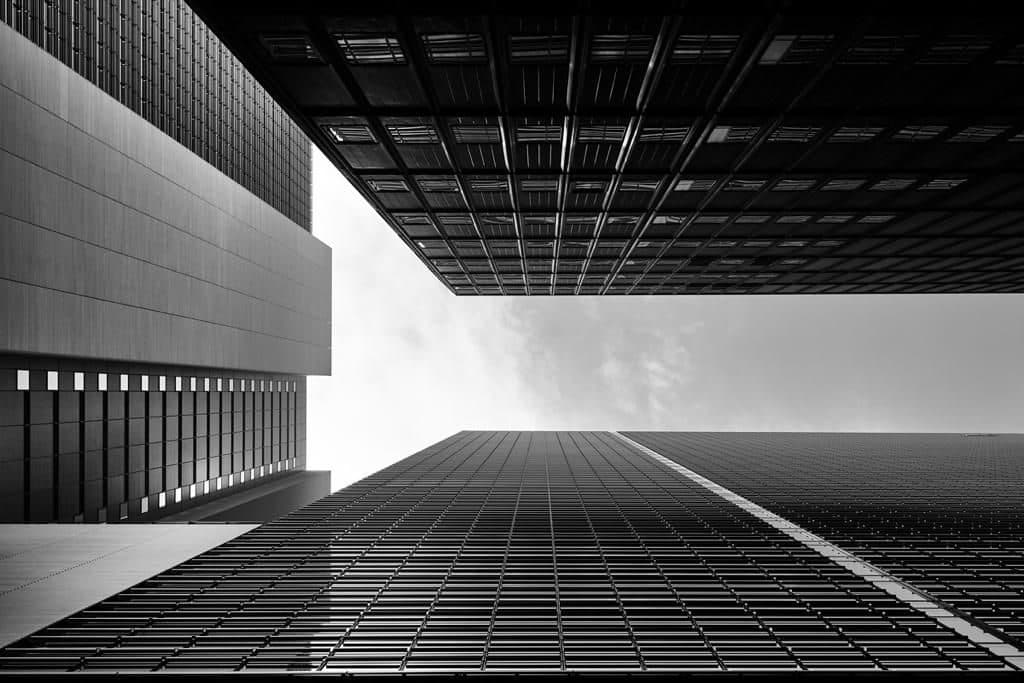 Looking up at a gridded skyscraper facade in black and white