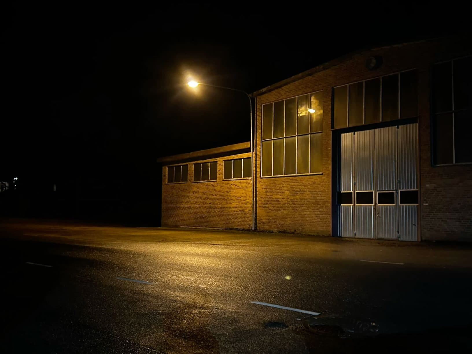 Warehouse district at dusk with brick buildings and a lit loading bay