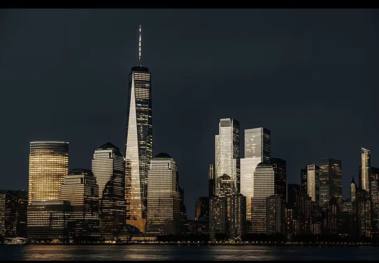 Lower Manhattan skyline at night, seen across the water