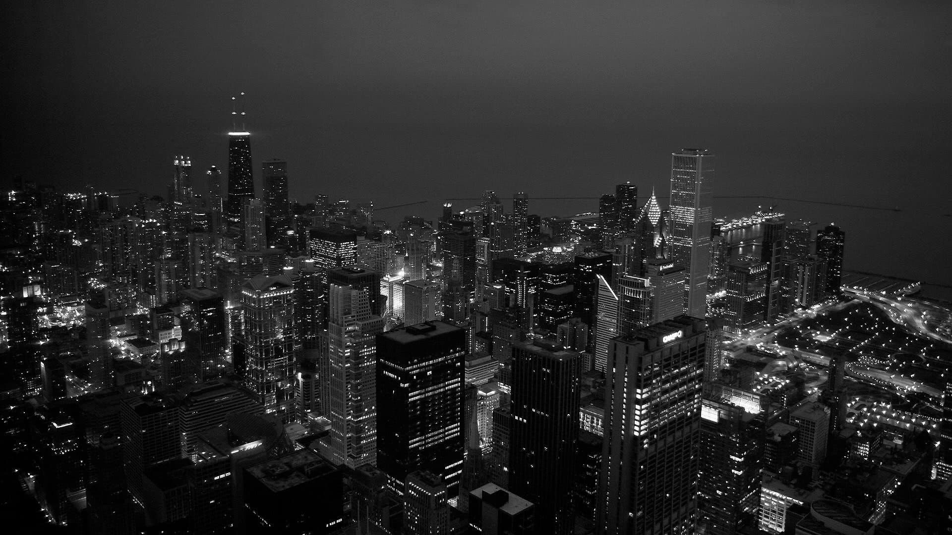 Aerial view of a dense city at night in black and white
